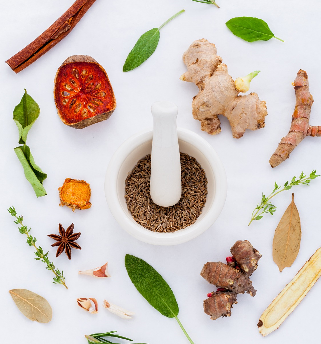 Closeup of several herbs and a mortar and pestle